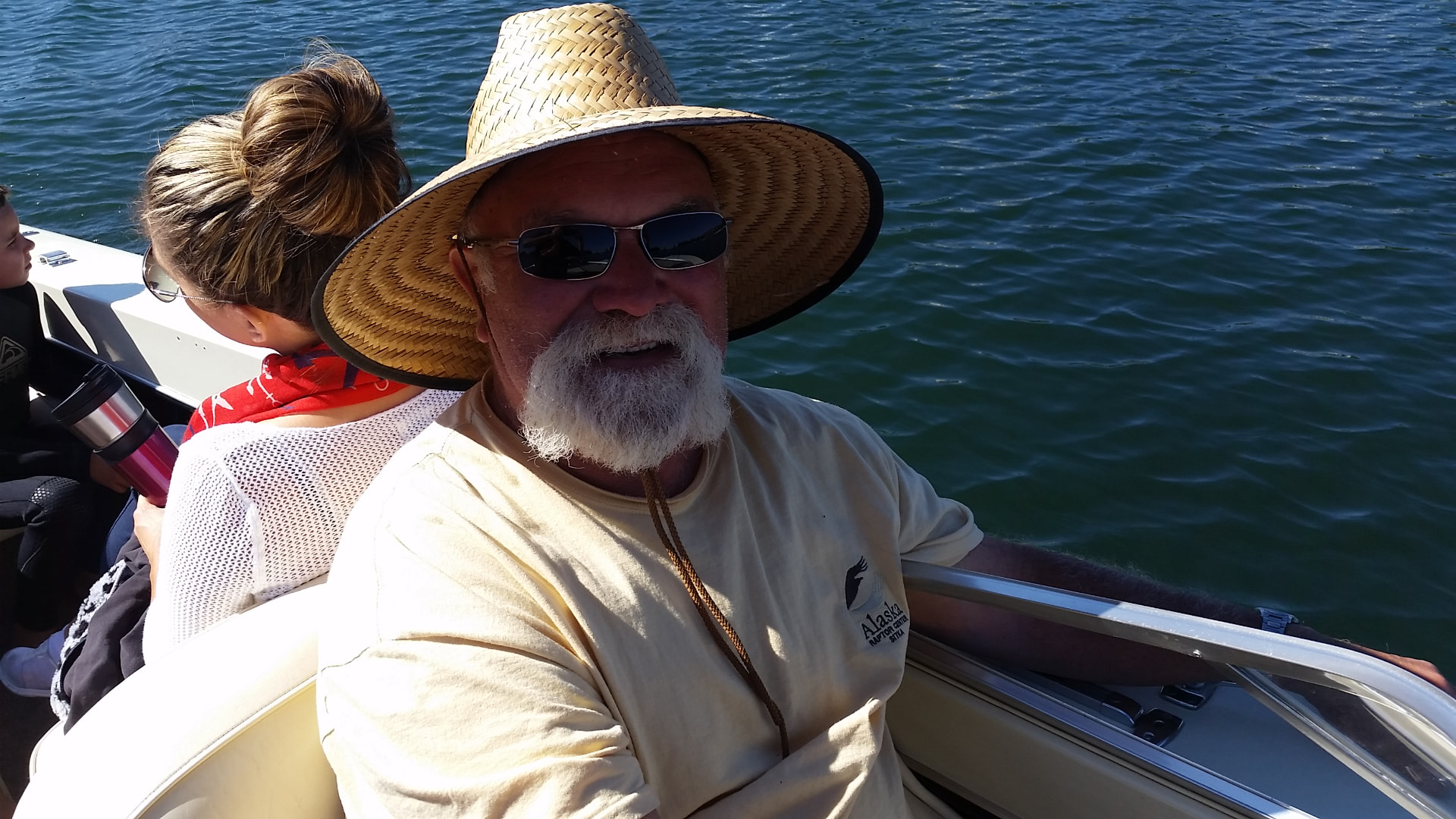 Andre in a straw hat and sunglasses aboard a boat on the water