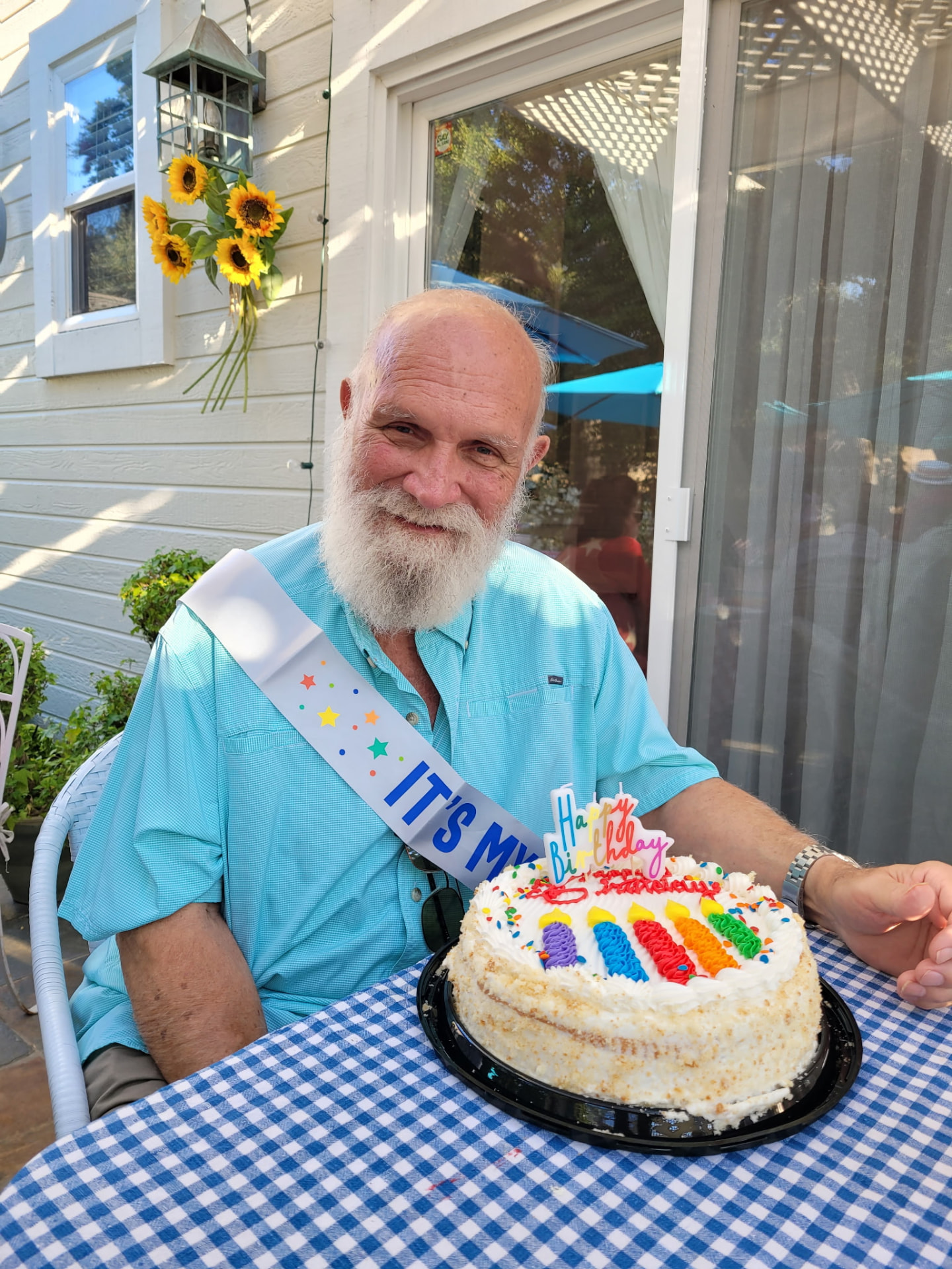 Andre holding a birthday cake outdoors
